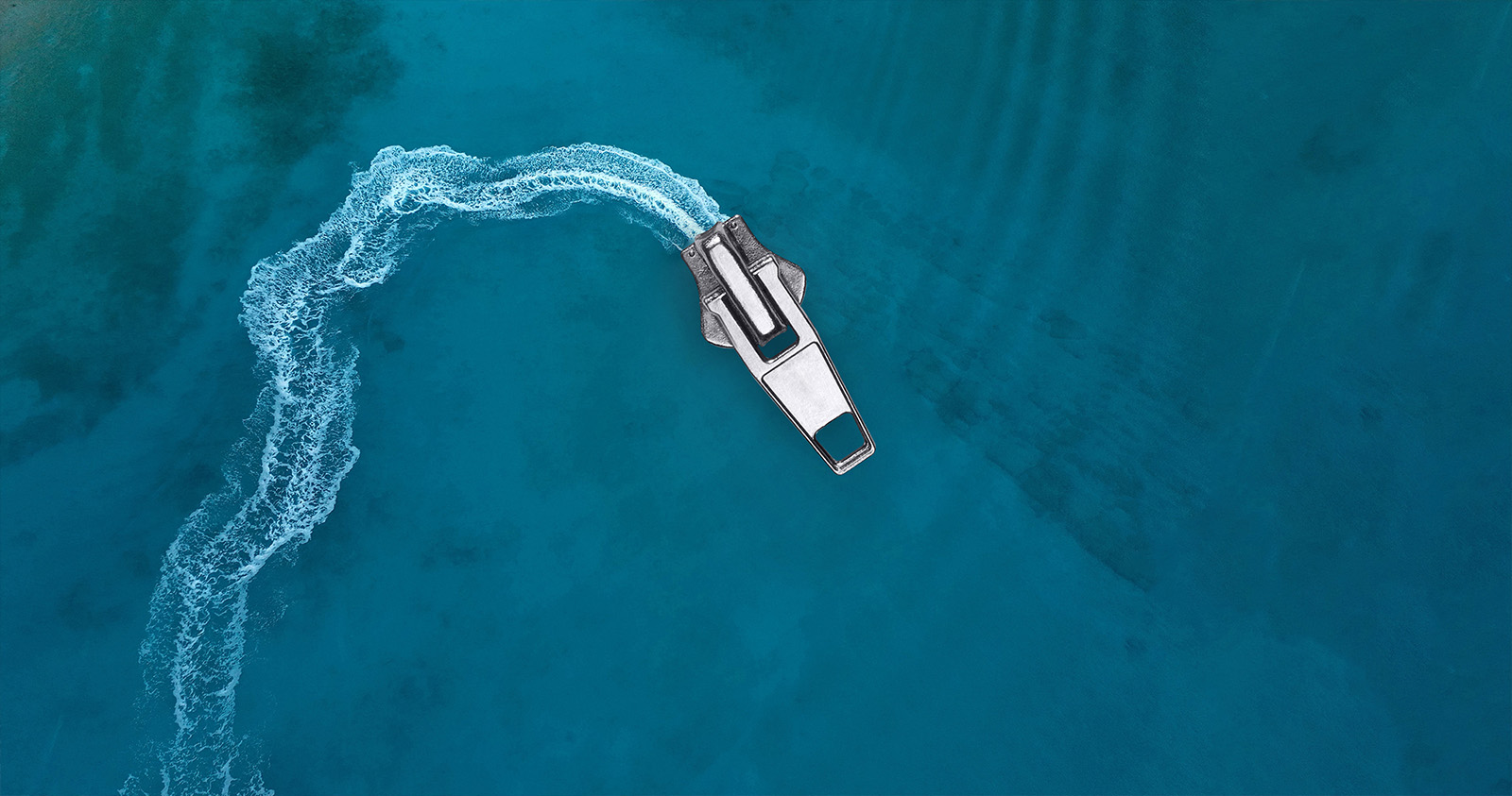 A zipper slider photographed as a boat cutting through turquoise water