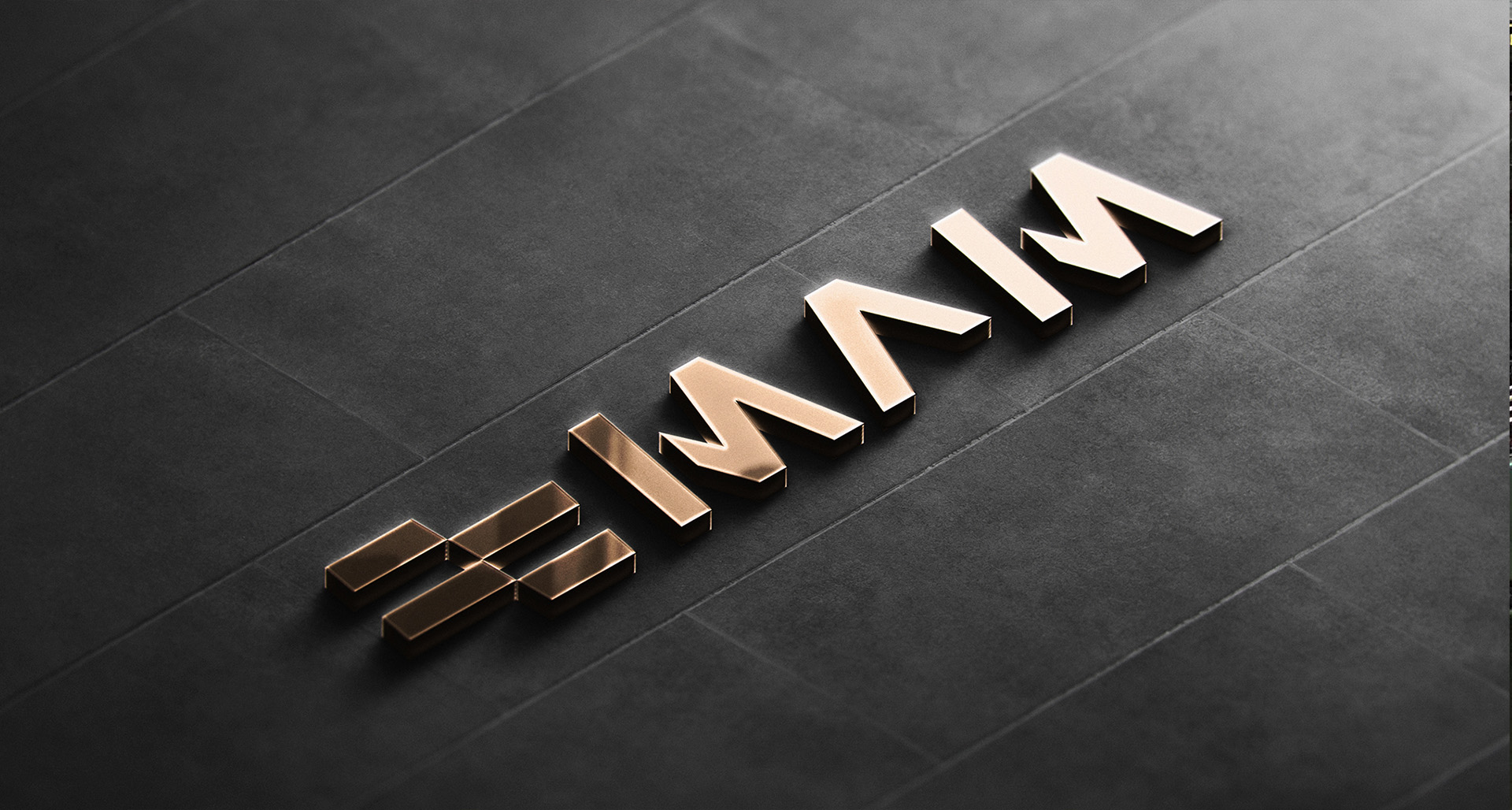 The MAM logo in polished bronze on a slate wall