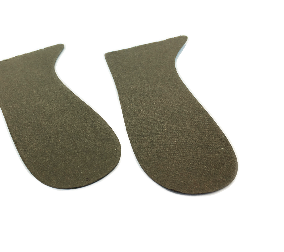 A pair of cut heel counters in green counterboard