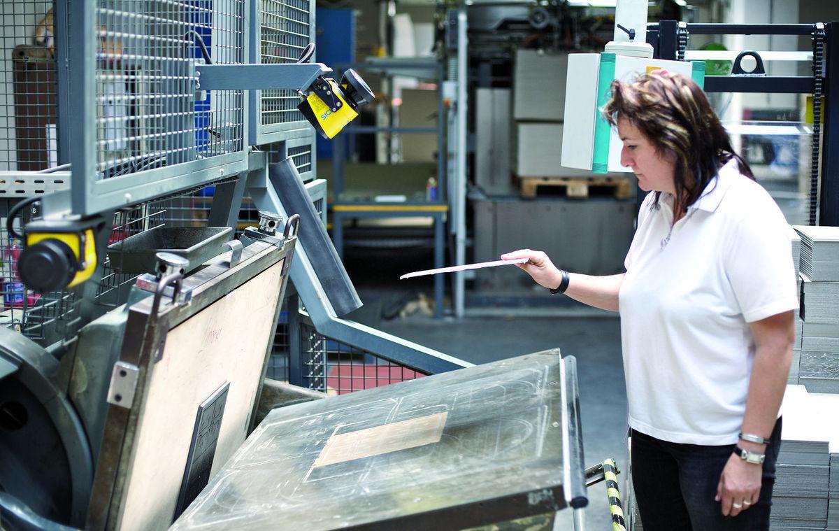 A Merckens operator checking a board sheet at the line